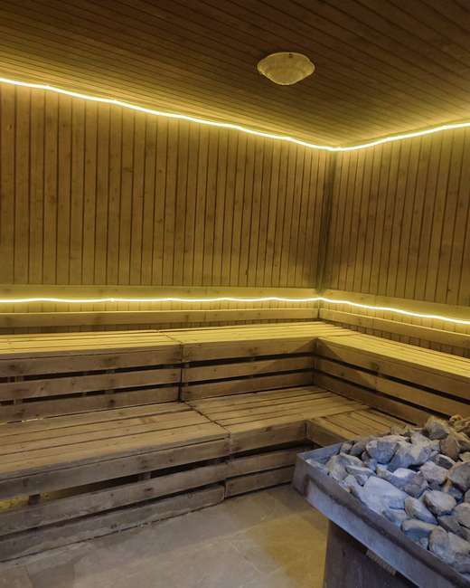 Sauna: ahşap sıralar ve taş yığını